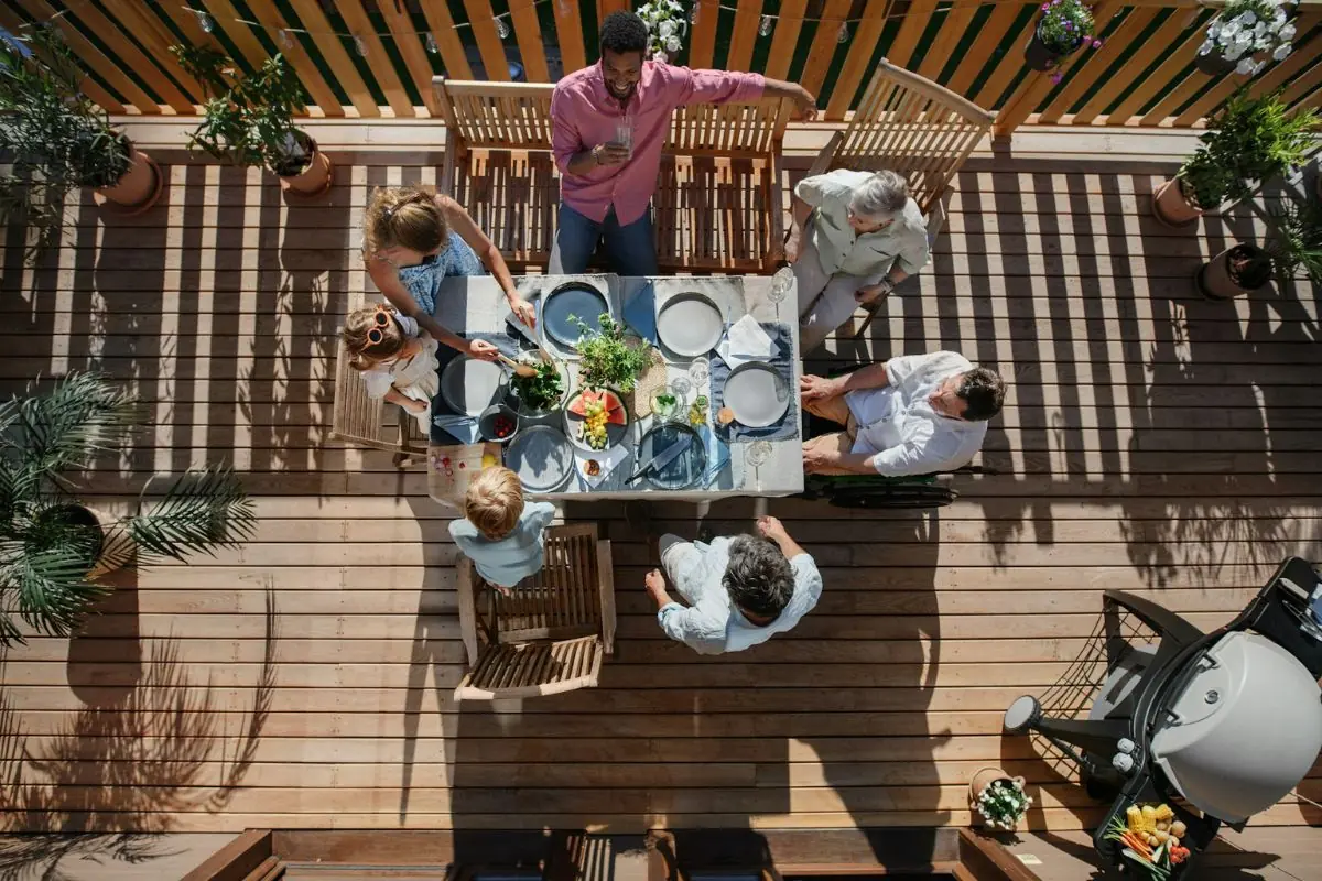 group of people eating together on backyard deck