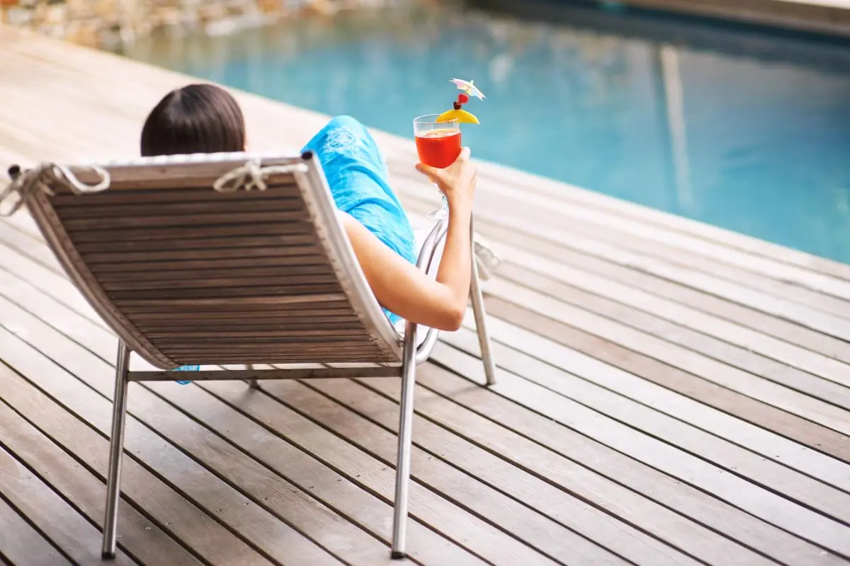 woman enjoying a drink on the pool deck