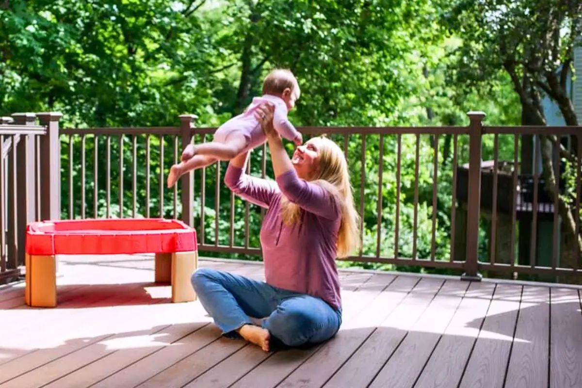 woman holding child on outdoor deck