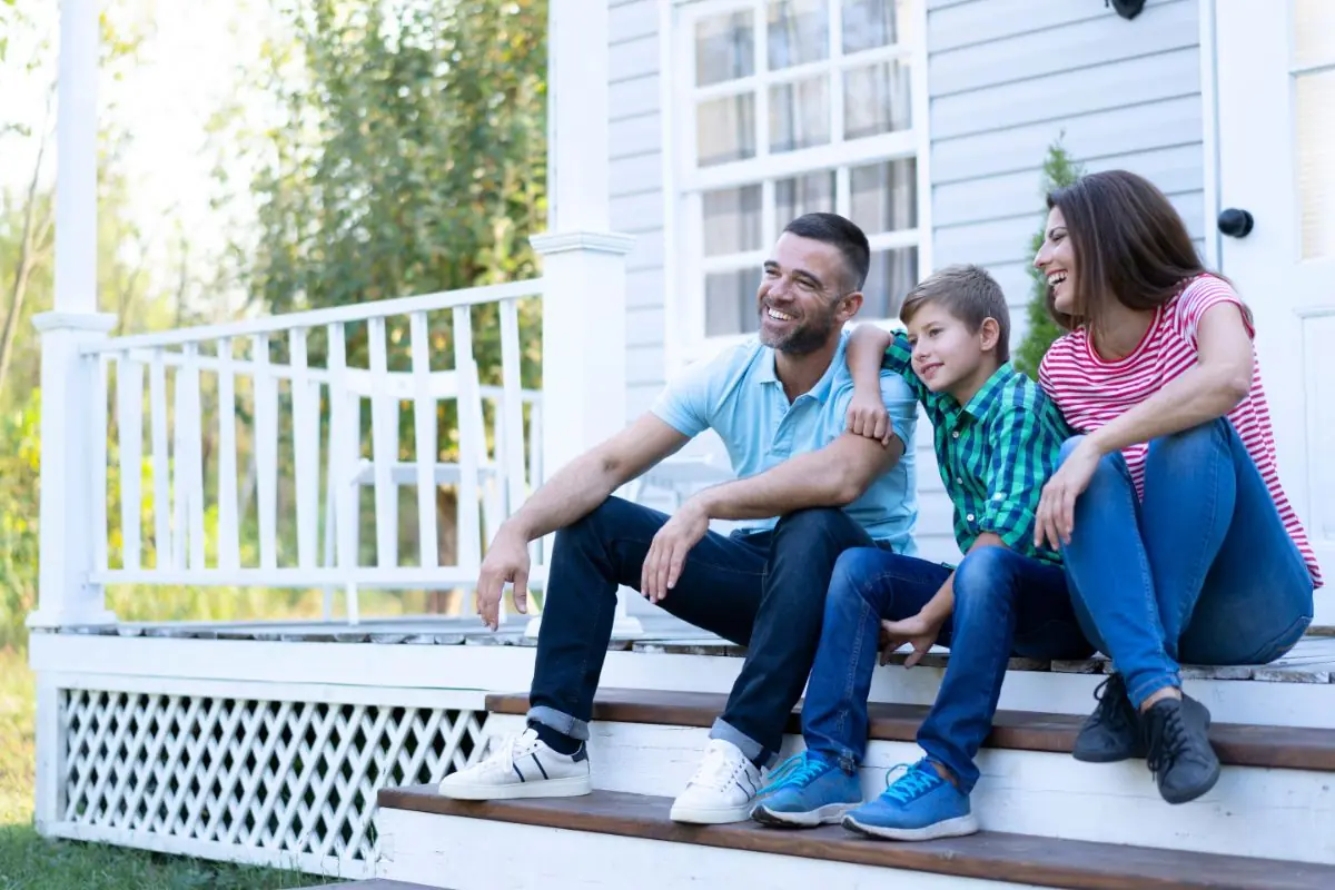 family sitting on front steps of their house