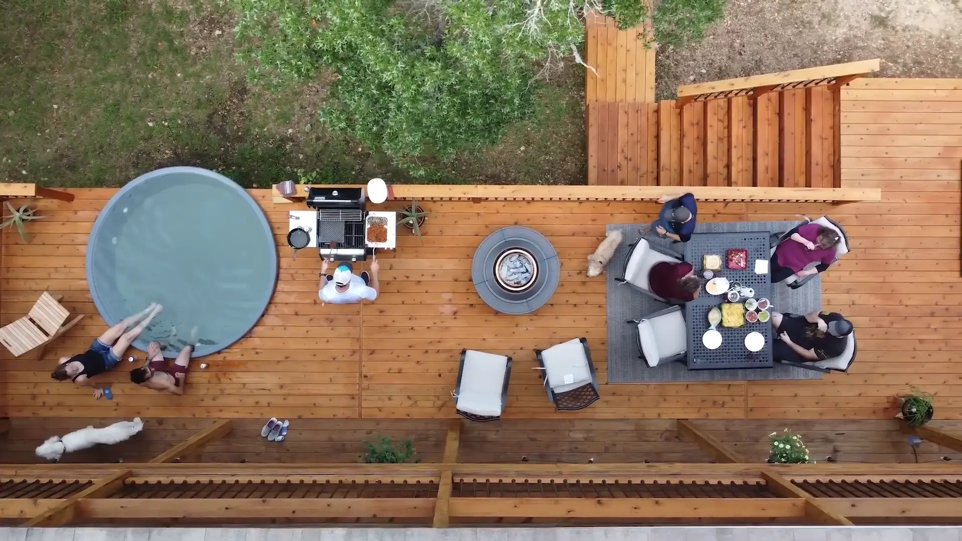 Top view of a beautifully designed backyard deck with seating, fire pit, and grill area. Make your outdoor dream space a reality—hire a professional contractor.